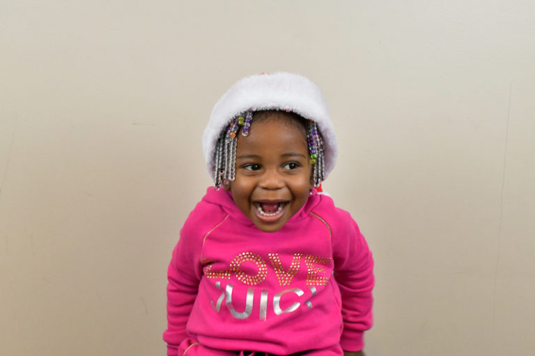 little girl with surprised face and Santa hat