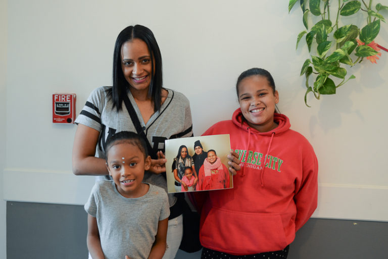 family holding framed photo